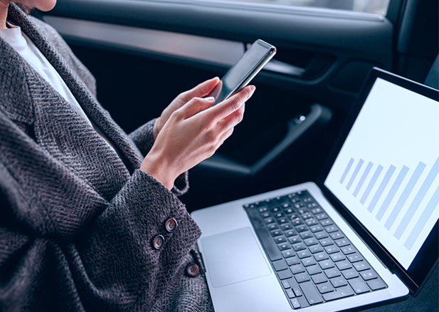 Field worker using a mobile phone and desktop supported by a unified communication solution from Bell to stay connected with colleagues and customers.